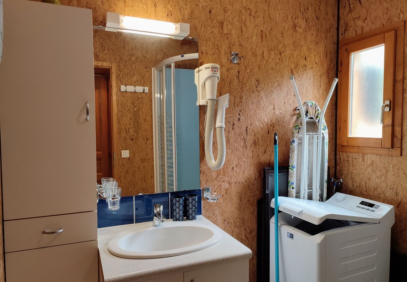 Salle de bain avec lave-linge, lavabo, douche et sèche-cheveux